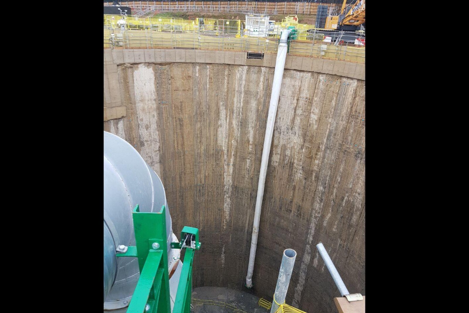 VENTEX Centrifugal Fan 800S on the edge of a large shaft with ducting hanging over the edge to the bottom of the shaft