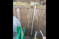 VENTEX Centrifugal Fan 800S on the edge of a large shaft with ducting hanging over the edge to the bottom of the shaft