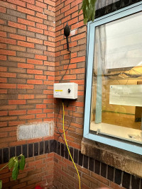 Monitex Area noise monitor mounted to the side of a building
