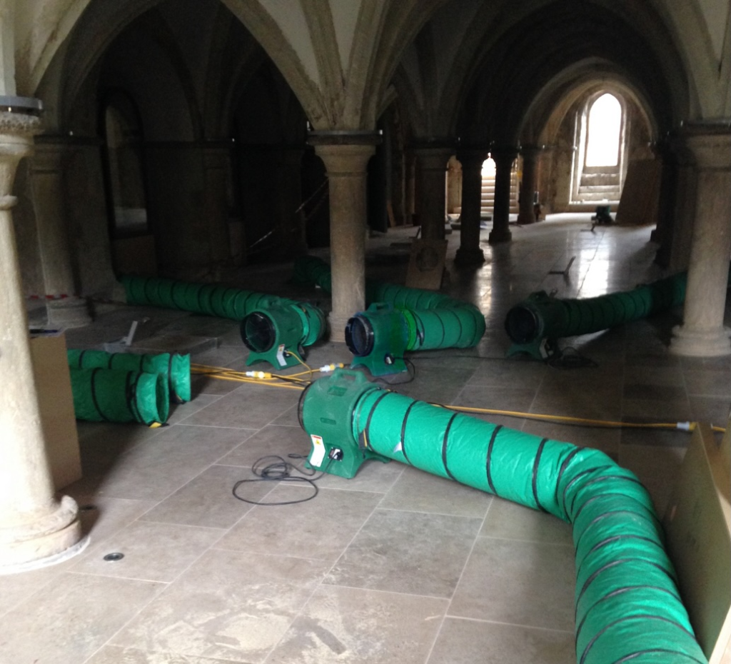 Green RVT ventilation fans and ducting set out in a vaulted stone undercroft