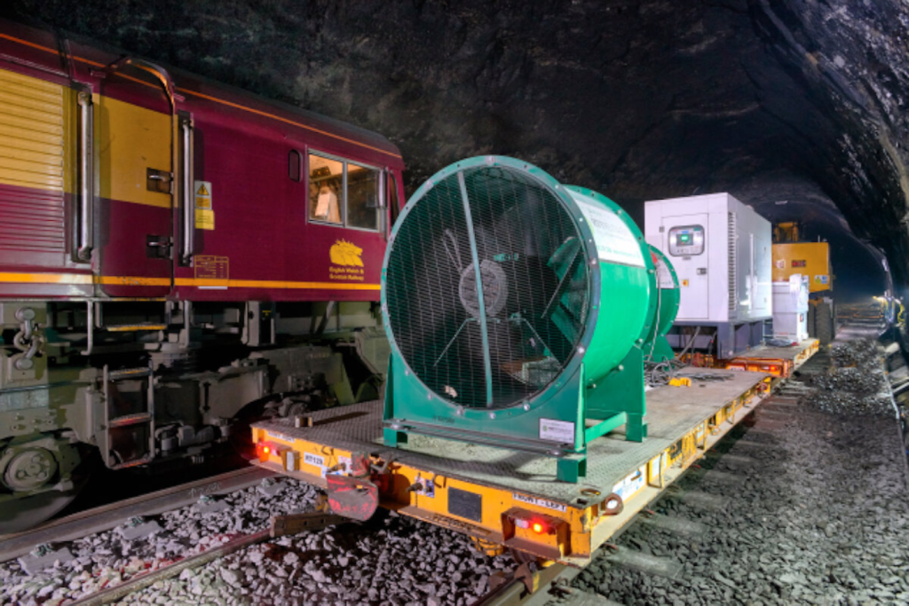 Green RVT axial ventilation fan on a rail wagon inside a railway tunnel