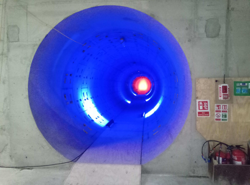 Tunnel ring lit in blue with a red light at the far end