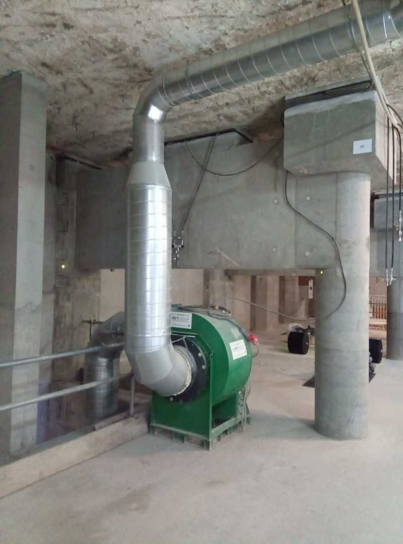 Green RVT fan with galvanised ducting in a concrete basement