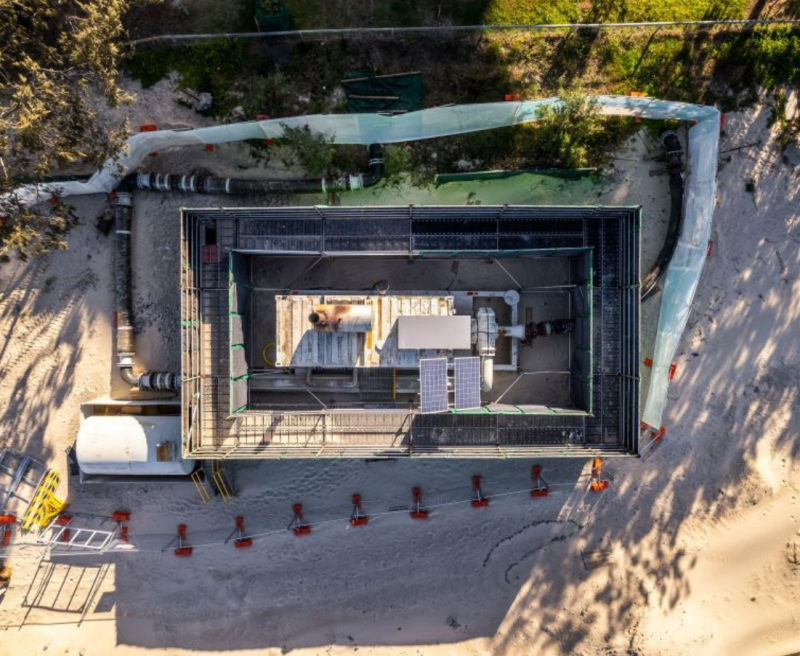Aerial view of a coastal construction pit with acoustic screening