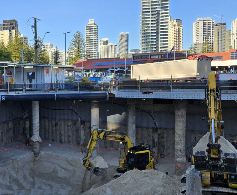 Excavators working in a deep excavation beside a Gold Coast transport station