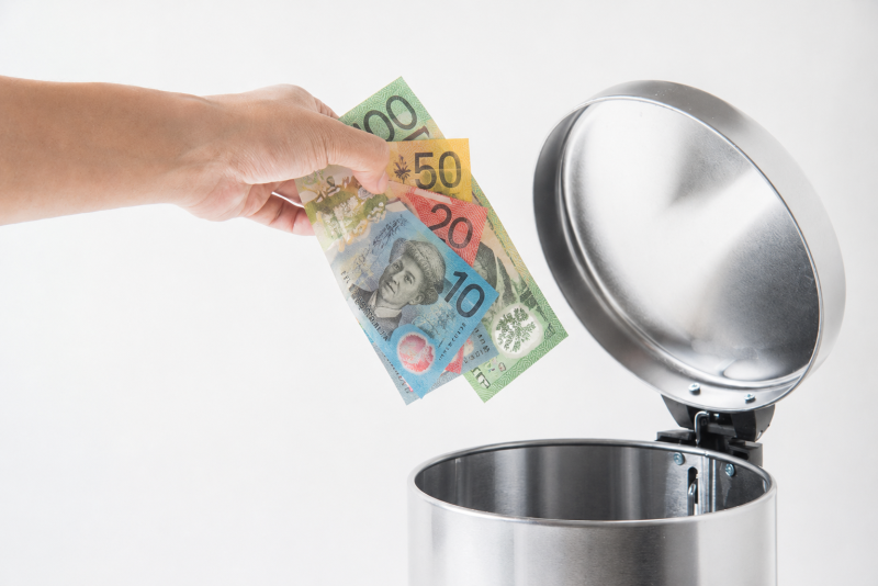 Australian dollar notes being thrown into a bin — illustrating the hidden costs of cheap hazard control