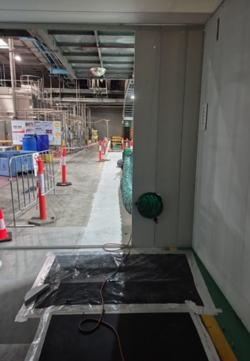Green ventilation ducting at the entrance to an industrial plant area