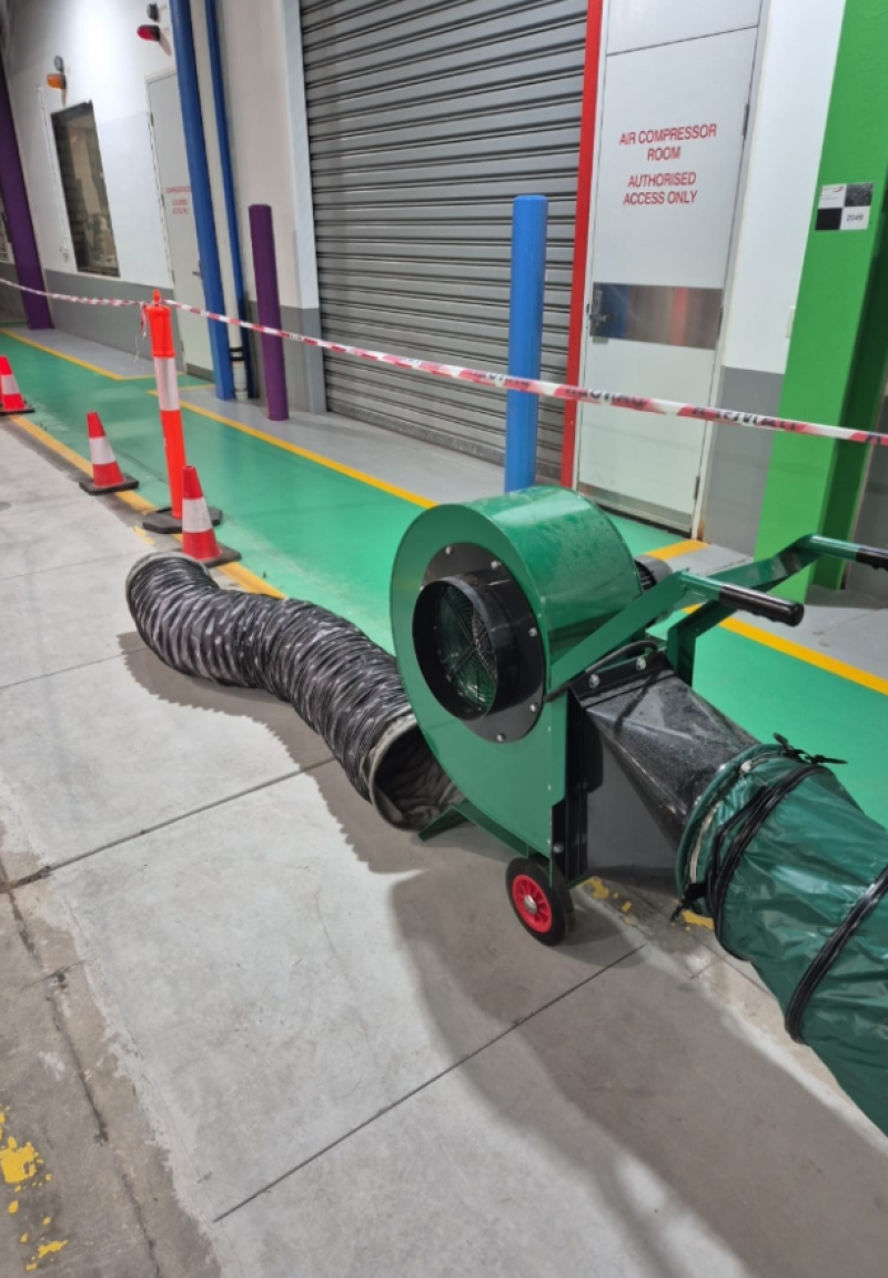 Green RVT ventilation fan and ducting in a warehouse corridor
