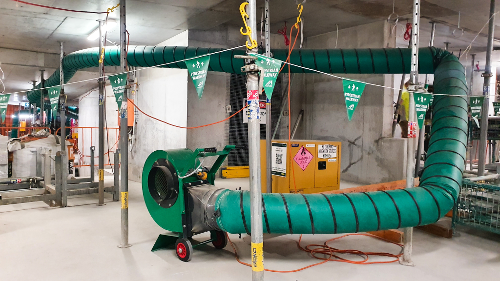 Green RVT ventilation fan and ducting suspended in a basement car park