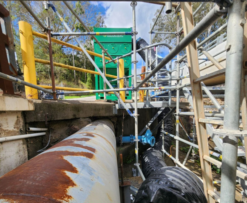 Green RVT unit and pipework beside scaffolding on a bridge maintenance site