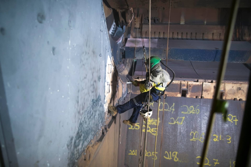 Worker abseiling to carry out works on a steel structure