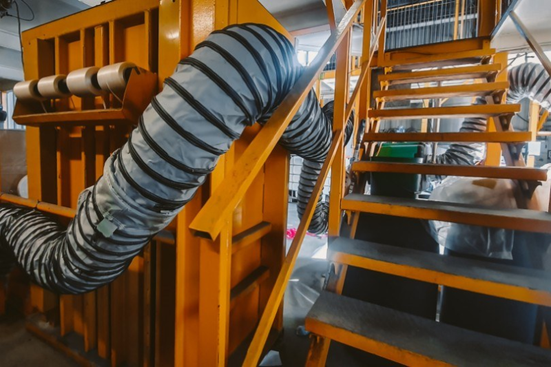 Flexible ventilation ducting run up a stairwell inside a building