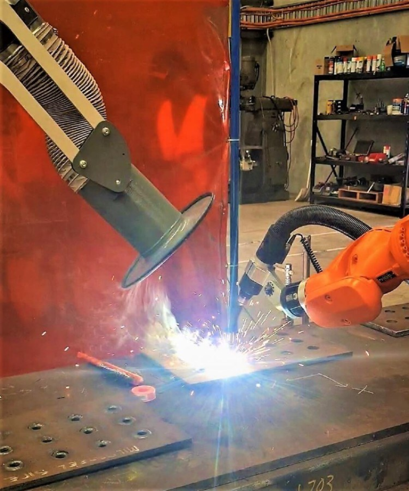 Robotic welding cell with a fume extraction arm capturing welding fume