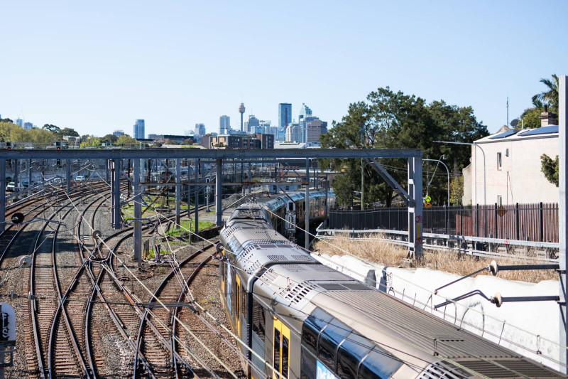 Sydney rail lines and a train with the city skyline behind